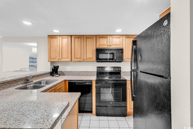 kitchen with a sink, black appliances, recessed lighting, and light tile patterned floors