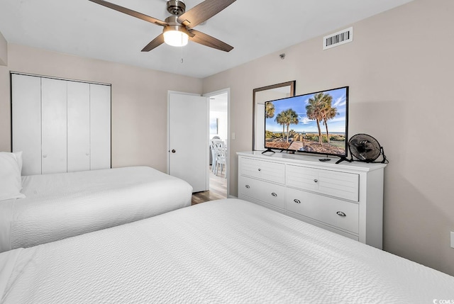 bedroom with visible vents, a closet, wood finished floors, and ceiling fan
