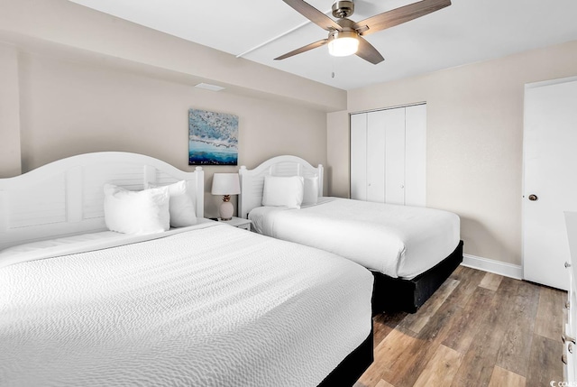 bedroom with a ceiling fan, baseboards, a closet, and wood finished floors