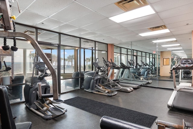 workout area featuring floor to ceiling windows, a drop ceiling, and visible vents