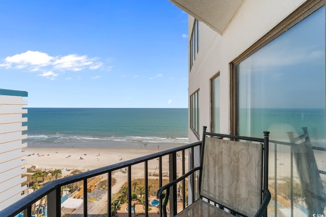 balcony featuring a water view and a beach view