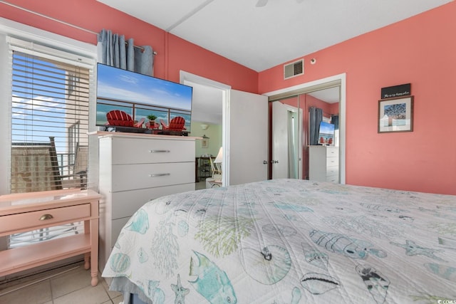tiled bedroom featuring visible vents and a closet