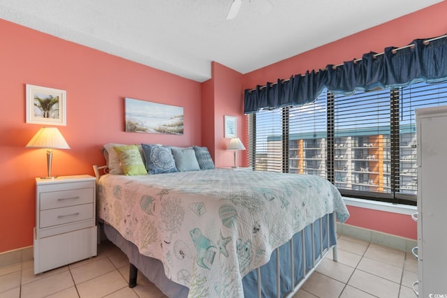 tiled bedroom featuring baseboards and a ceiling fan