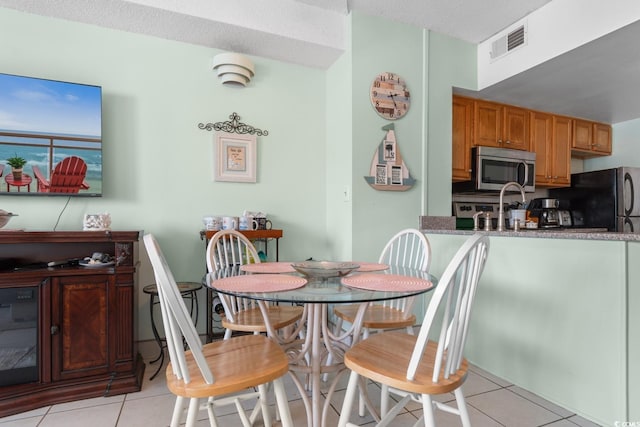 dining room featuring light tile patterned flooring and visible vents