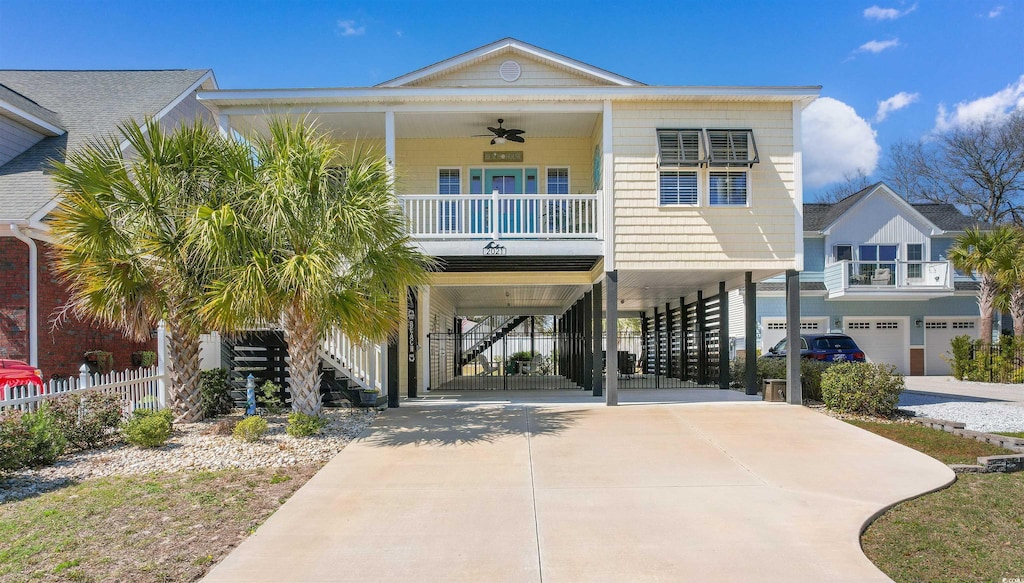2021 Ye Olde Kings Hwy, North Myrtle Beach, SC 29582 - coastal home with driveway, covered porch, stairway, a carport, and ceiling fan