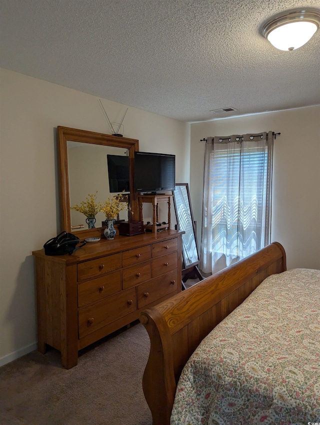 bedroom featuring carpet floors and a textured ceiling