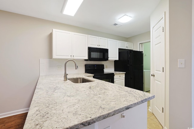 kitchen featuring black appliances, a sink, white cabinetry, tasteful backsplash, and light stone countertops