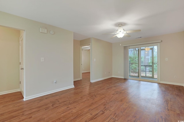 spare room with a ceiling fan, wood finished floors, and baseboards