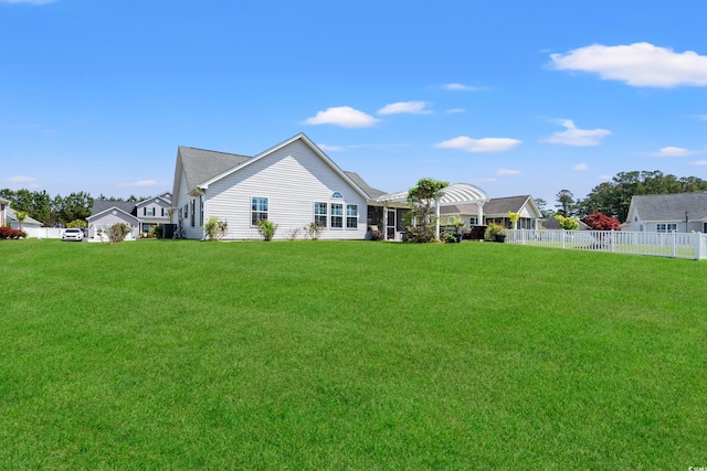 back of house with a lawn and fence
