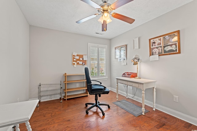 office space featuring visible vents, a ceiling fan, baseboards, and wood finished floors