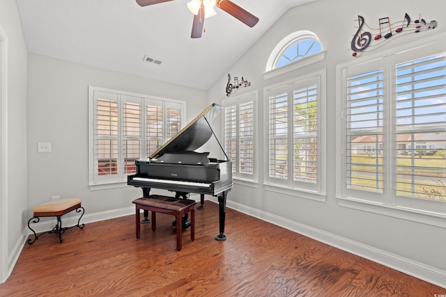 living area with a ceiling fan, visible vents, wood finished floors, baseboards, and lofted ceiling