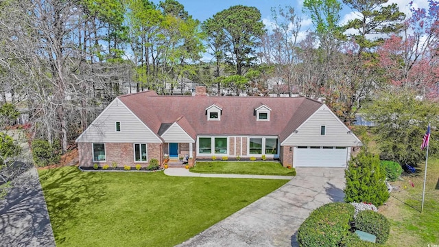 cape cod-style house with a front yard, a chimney, brick siding, an attached garage, and driveway