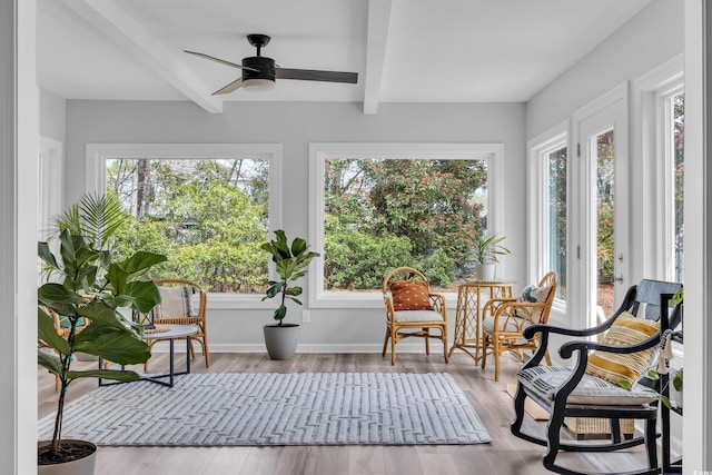 sunroom / solarium featuring baseboards, beamed ceiling, and wood finished floors