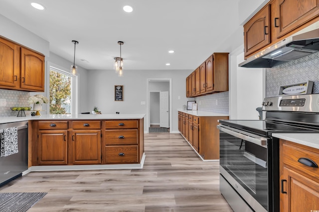 kitchen featuring under cabinet range hood, brown cabinets, and stainless steel appliances