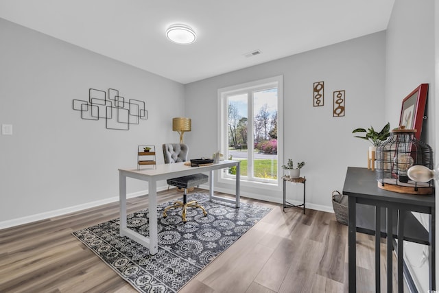 home office featuring baseboards, wood finished floors, and visible vents