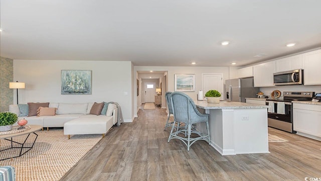 4481 E Coast Ln, Shallotte, NC 28470 - kitchen featuring stainless steel appliances, light wood-style flooring, a breakfast bar, white cabinetry, and recessed lighting
