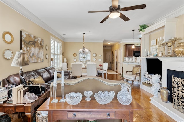 living room featuring light wood-style floors, ceiling fan, and crown molding