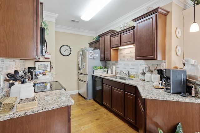 kitchen featuring appliances with stainless steel finishes, a sink, light wood finished floors, tasteful backsplash, and ornamental molding