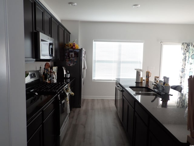 447 Archer Ct, Conway, SC 29526 - kitchen with dark cabinets, light wood-type flooring, a sink, stainless steel appliances, and baseboards
