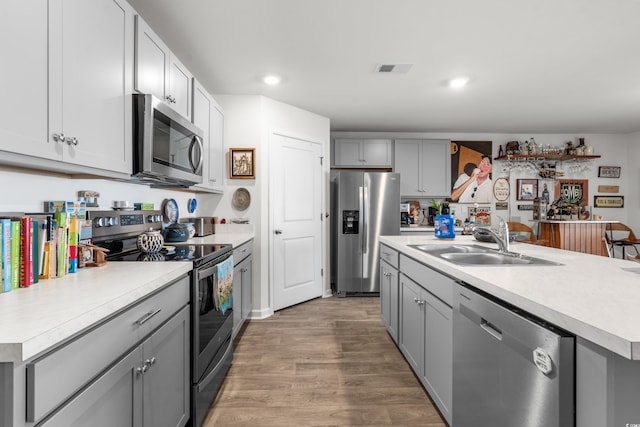 kitchen with stainless steel appliances, light countertops, a sink, and gray cabinets