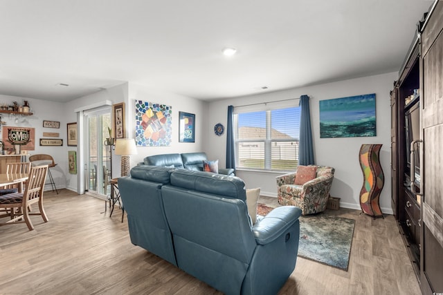 living area featuring visible vents, baseboards, and light wood-style floors