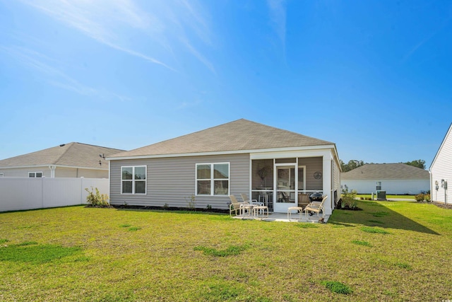rear view of property with a patio area, fence, a yard, and a sunroom