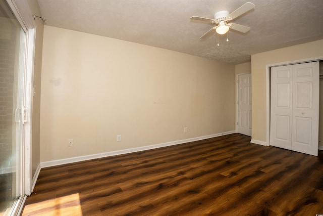 unfurnished bedroom featuring a ceiling fan, baseboards, a textured ceiling, and dark wood-style floors