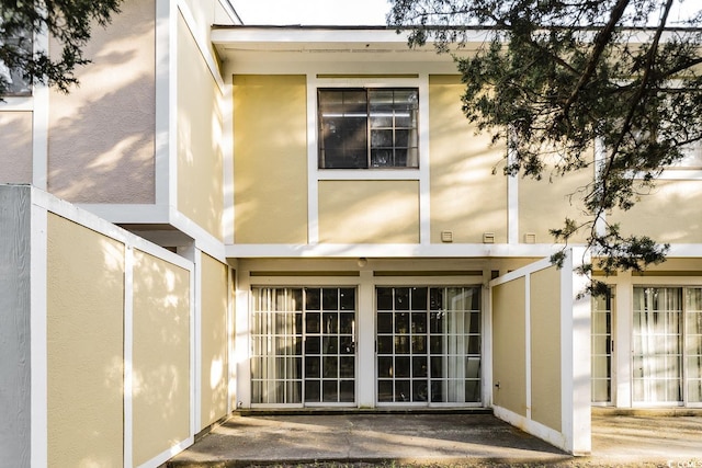 rear view of house with stucco siding and a patio area
