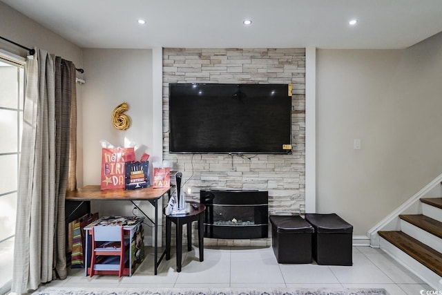 tiled living area with a stone fireplace, baseboards, stairway, and recessed lighting