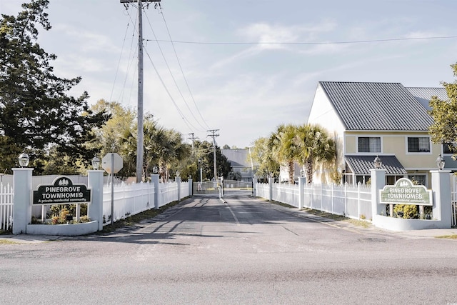 view of street with a gate, traffic signs, and a gated entry