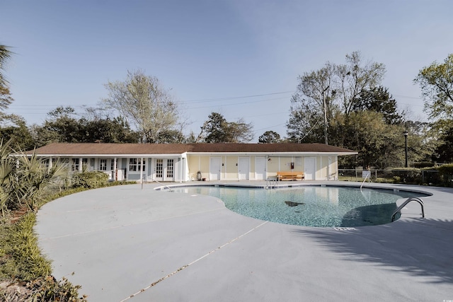 pool featuring fence, a patio area, and french doors