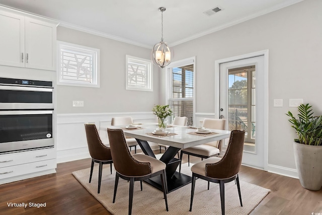 5885 Ledro Ln, Myrtle Beach, SC 29572 - dining room featuring ornamental molding, dark wood-type flooring, a wainscoted wall, and a chandelier