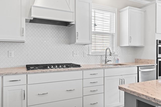 5885 Ledro Ln, Myrtle Beach, SC 29572 - kitchen with stainless steel appliances, white cabinetry, custom exhaust hood, backsplash, and light stone counters