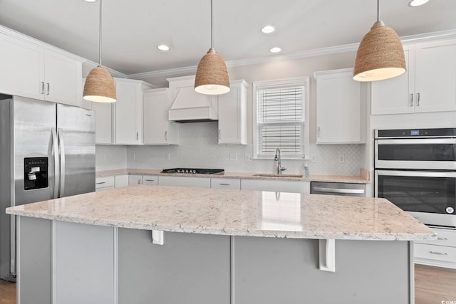 5885 Ledro Ln, Myrtle Beach, SC 29572 - kitchen with appliances with stainless steel finishes, a kitchen island, premium range hood, wood finished floors, and crown molding