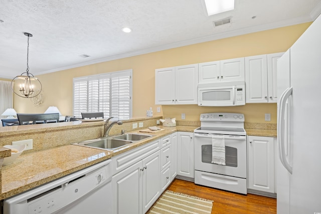 kitchen with a sink, light countertops, crown molding, and white appliances