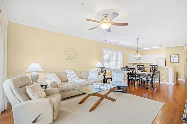 living area featuring ornamental molding, a ceiling fan, and light wood-type flooring