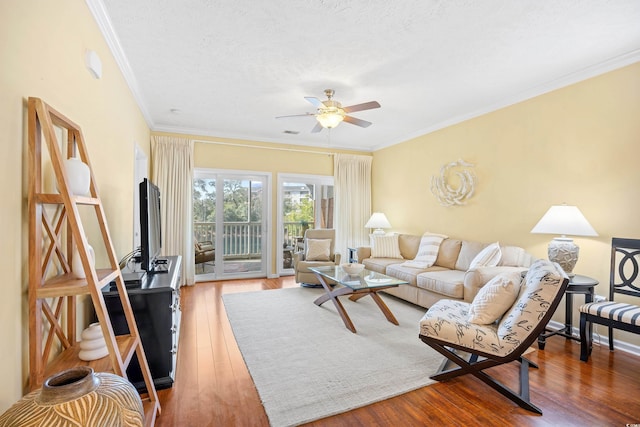 living room with crown molding, a ceiling fan, and wood finished floors