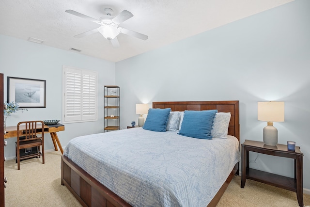 bedroom with visible vents, baseboards, ceiling fan, and light carpet