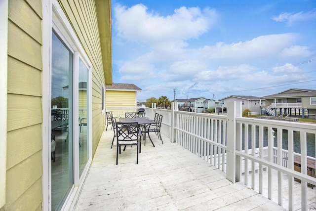 wooden terrace with a residential view and outdoor dining space