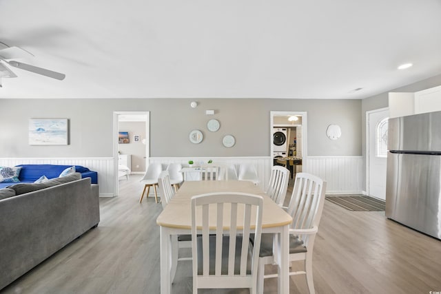 dining area featuring washer / dryer, light wood-type flooring, a ceiling fan, and wainscoting
