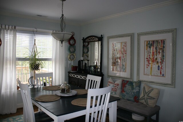 dining room with a healthy amount of sunlight, crown molding, and visible vents