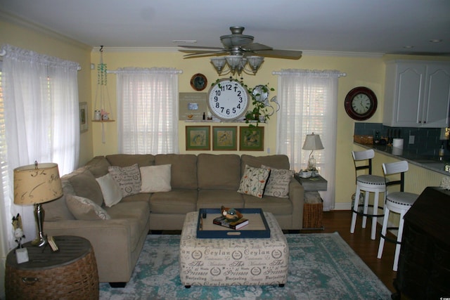 living area featuring crown molding, wood finished floors, and a ceiling fan