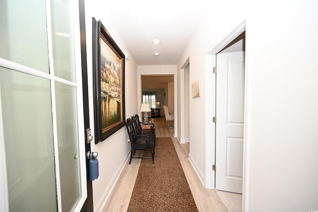 hallway featuring recessed lighting, baseboards, and light wood-type flooring
