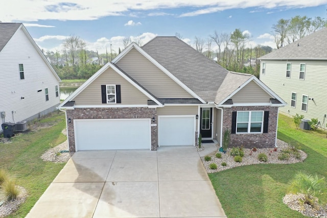 craftsman house featuring cooling unit, driveway, a front lawn, and brick siding