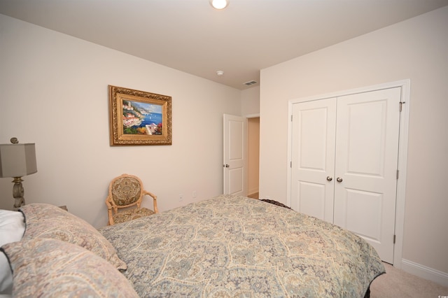bedroom featuring carpet flooring, baseboards, visible vents, and a closet