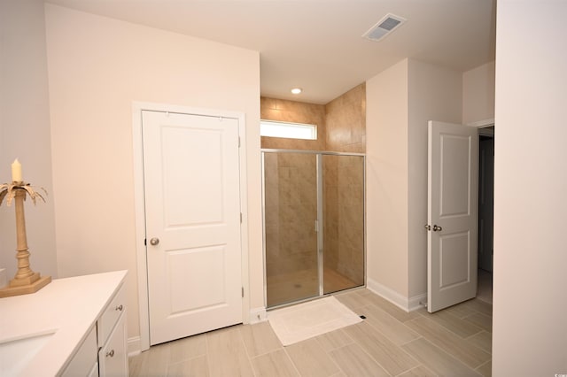 full bathroom with baseboards, visible vents, a shower stall, and vanity