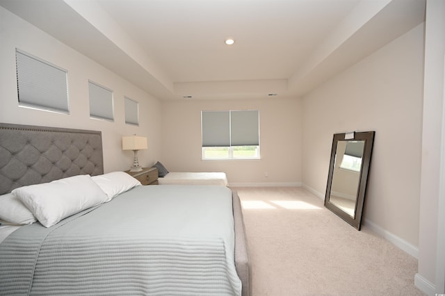 carpeted bedroom with baseboards, recessed lighting, and a raised ceiling