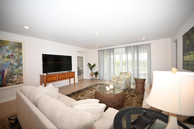 living area featuring recessed lighting, baseboards, and wood finished floors