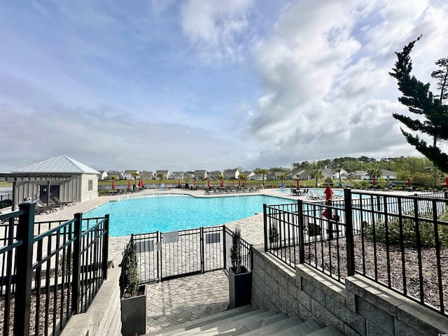 pool featuring fence and a patio