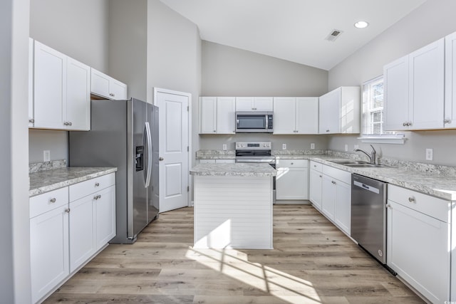 kitchen with a sink, high vaulted ceiling, stainless steel appliances, white cabinets, and visible vents